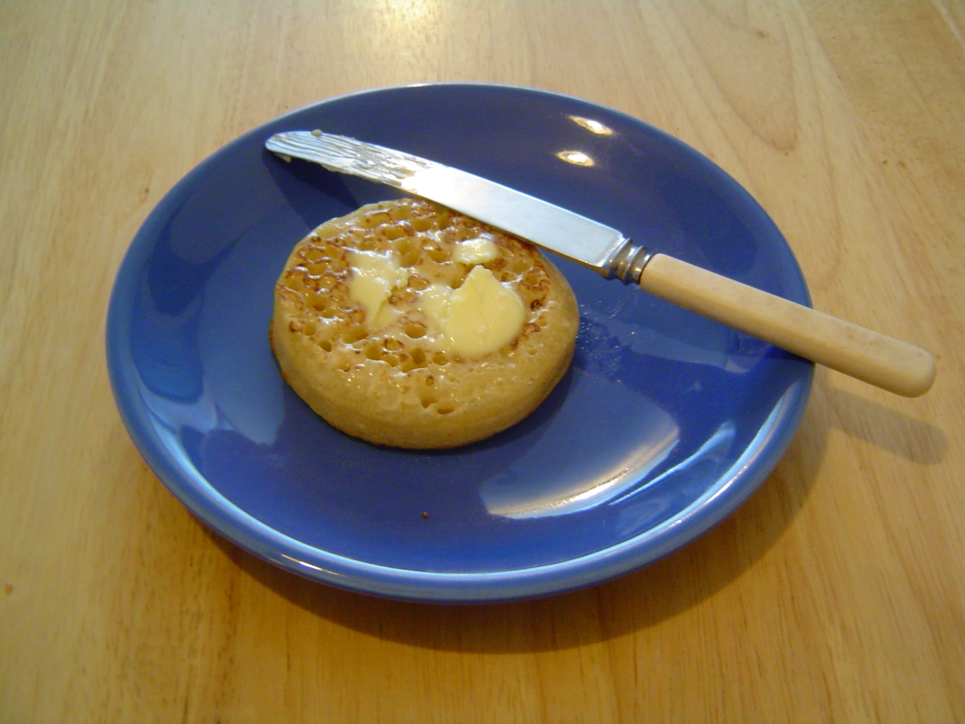 A buttered crumpet on a plate