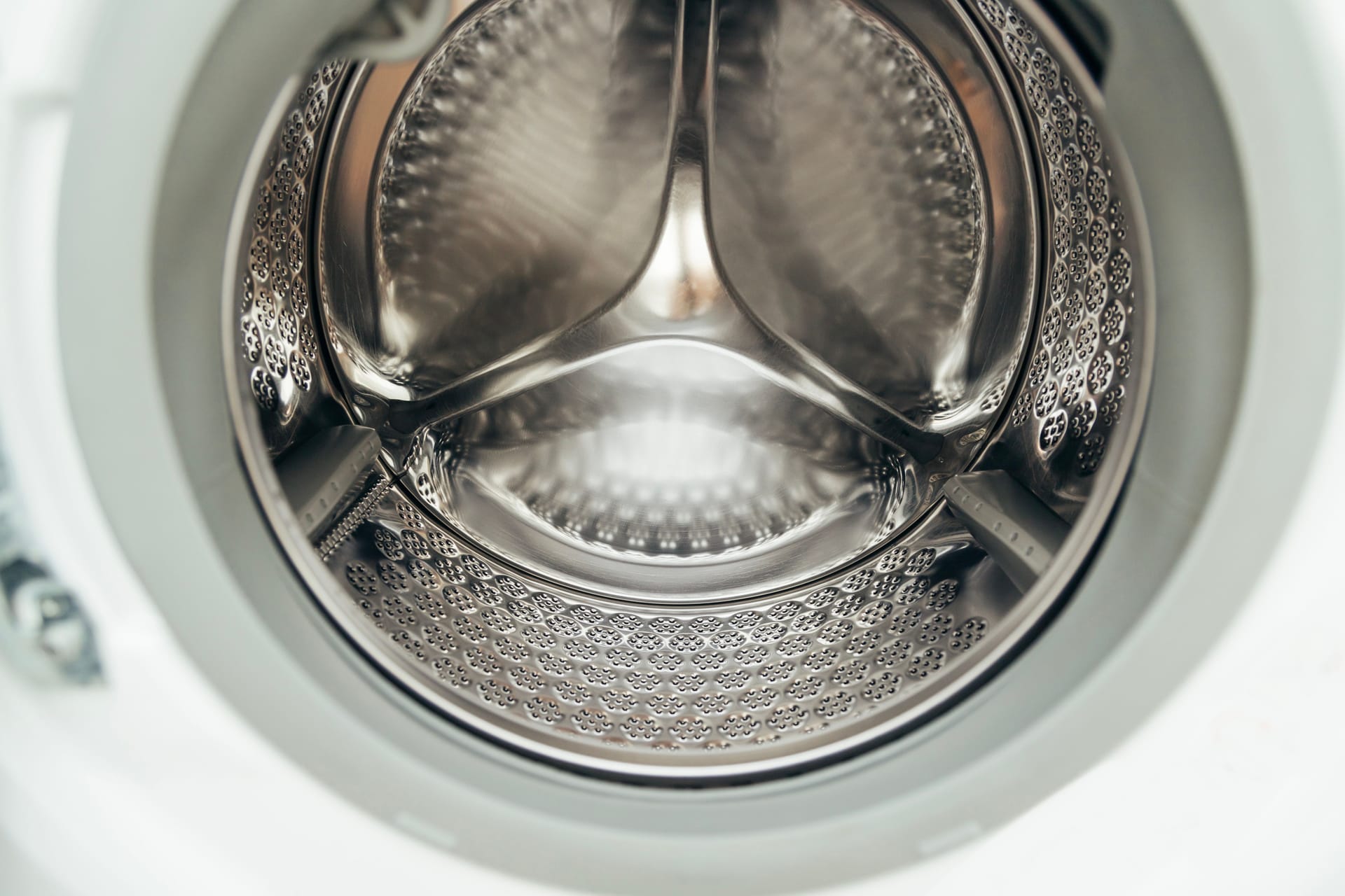 The clean stainless steel drum of a front-loading washing machine