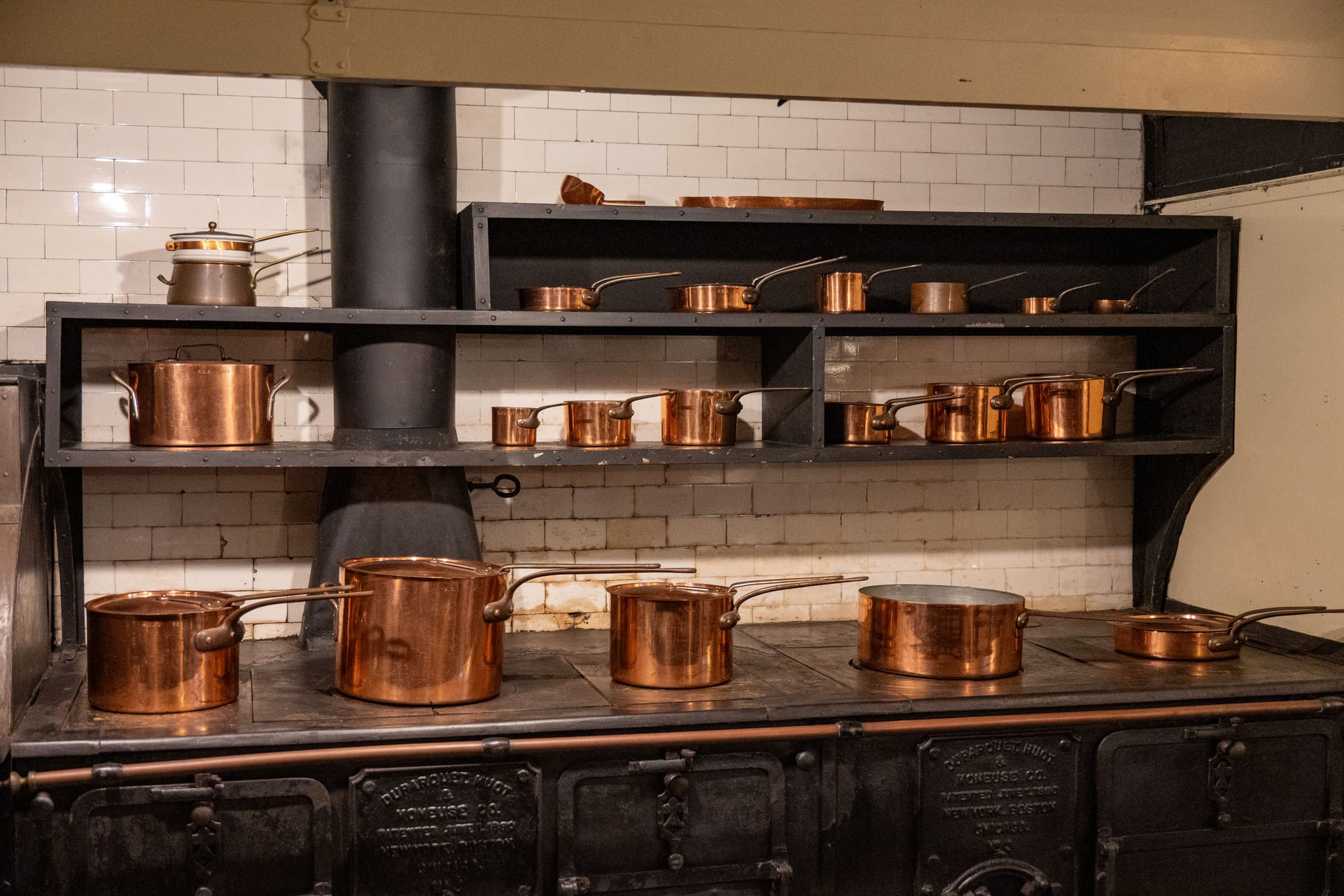 A collection of copper pans on a traditional stove