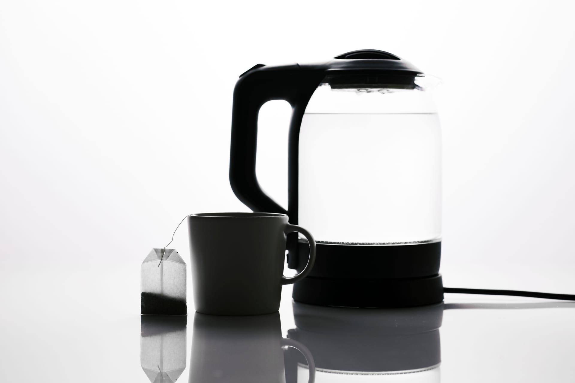 An electric kettle beside a mug and teabag on a worktop