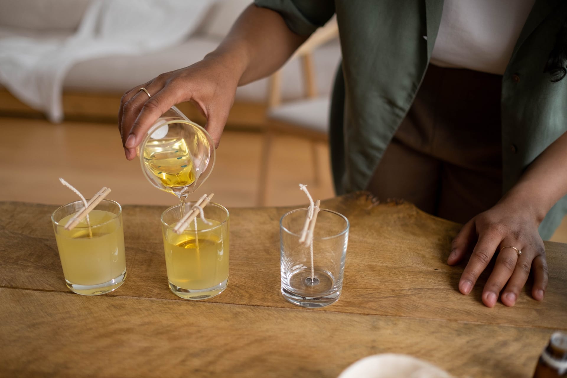Pouring wax into glass jars to make candles