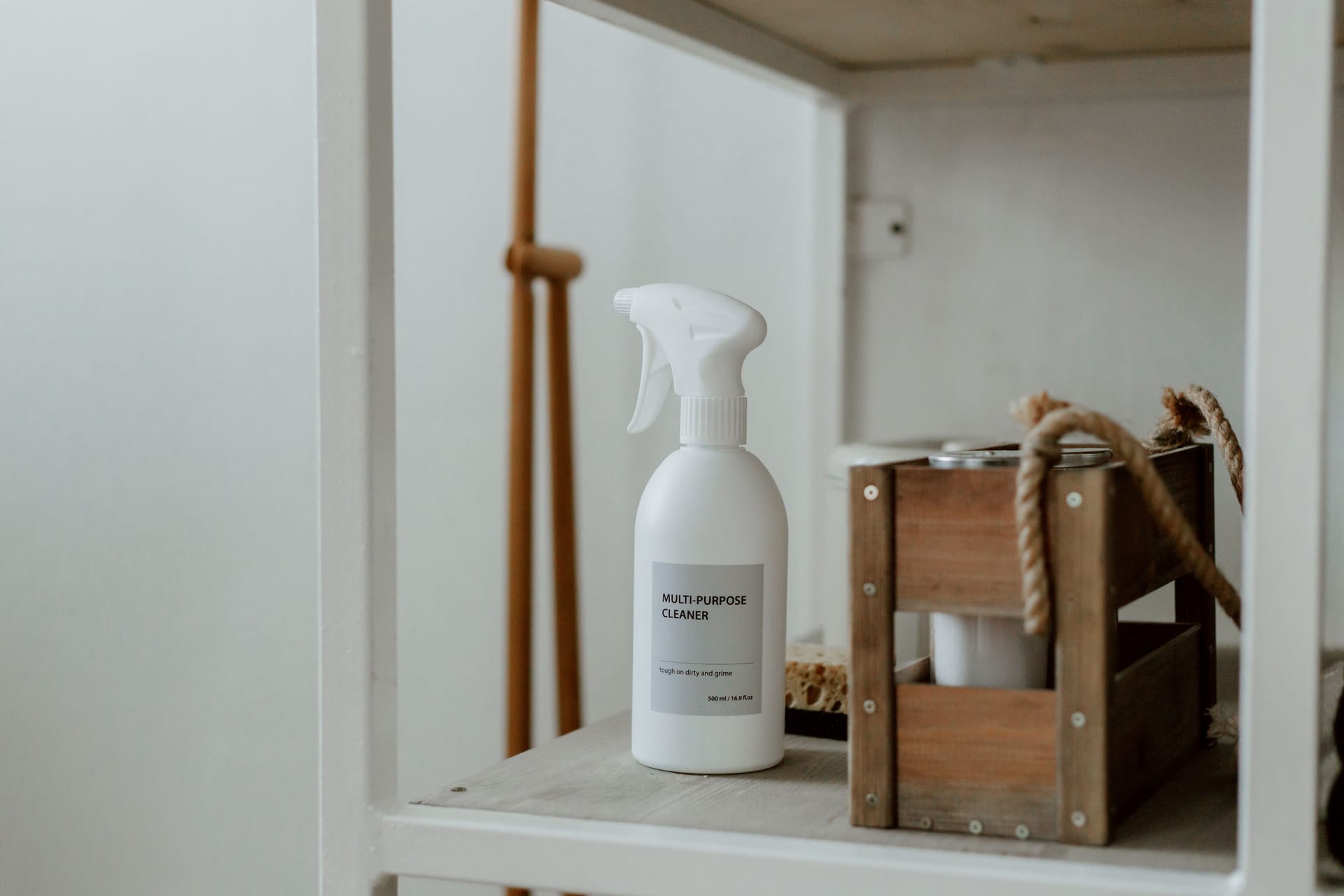 A spray cleaner and a wooden caddy on a clean shelf