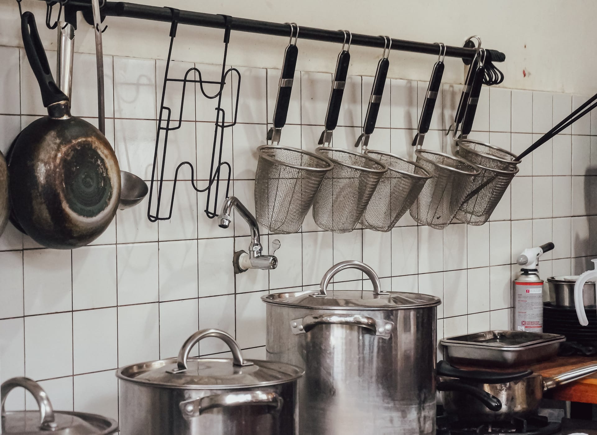 Metal cooking pots and utensils hanging in a kitchen