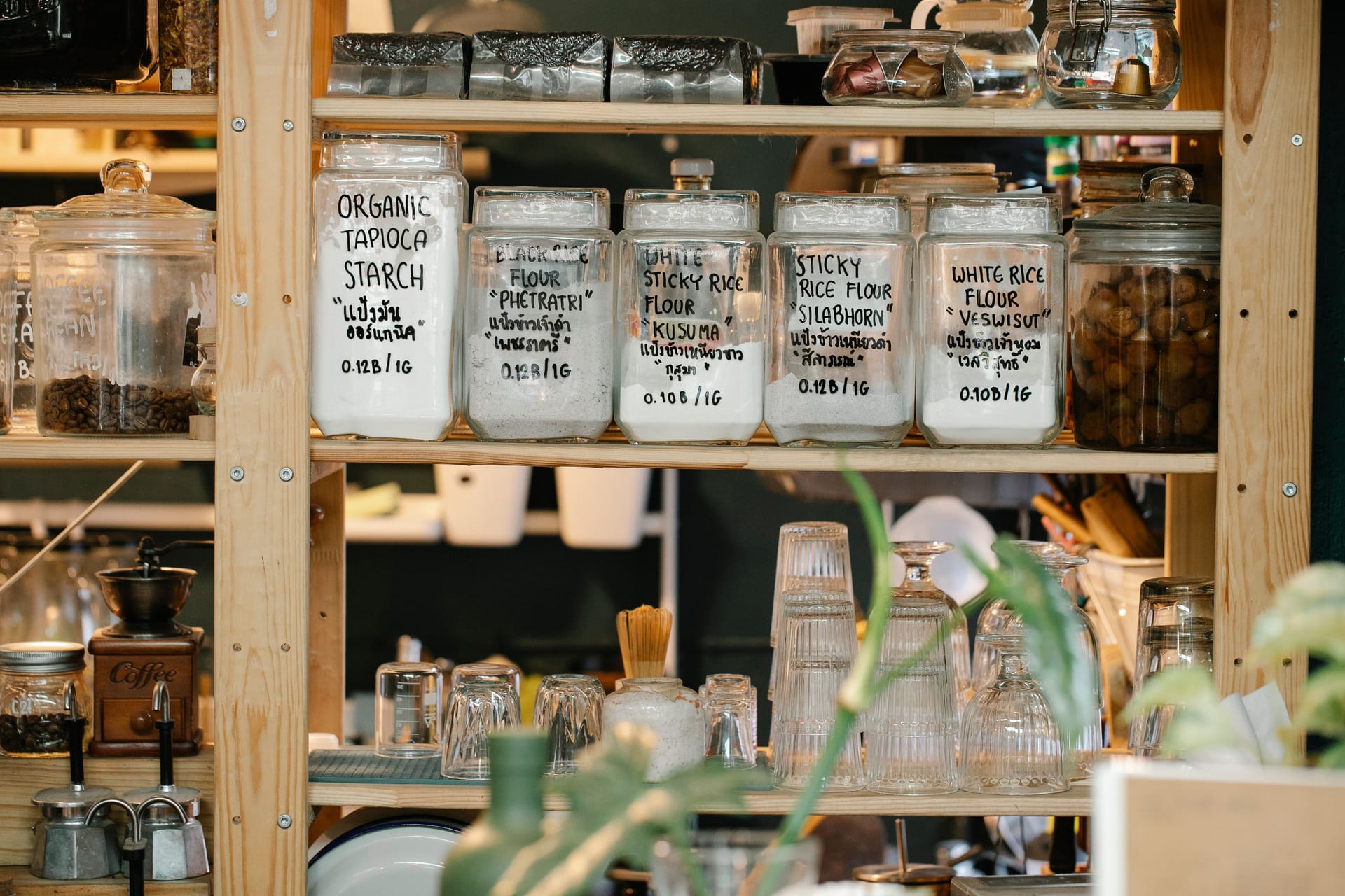 Glass jars of dry food on a wooden shelf