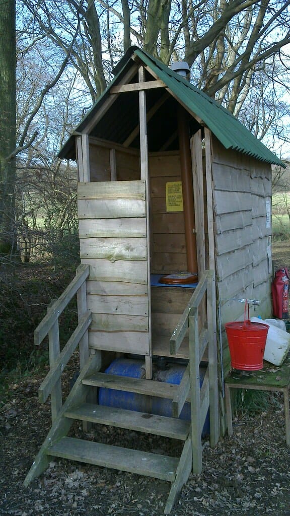 A timber composting toilet hut in woodland