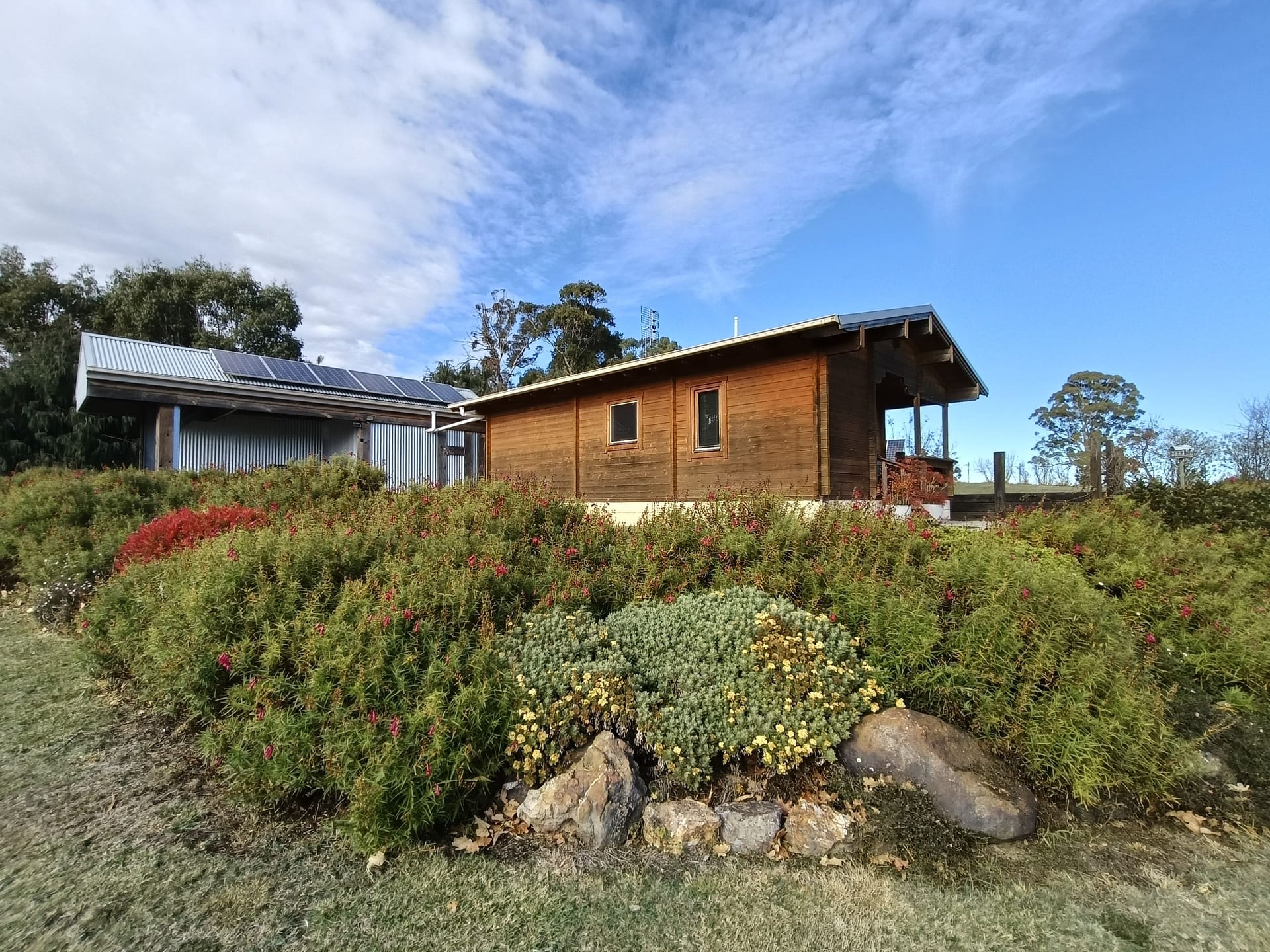 A timber cabin with solar panels on rural land