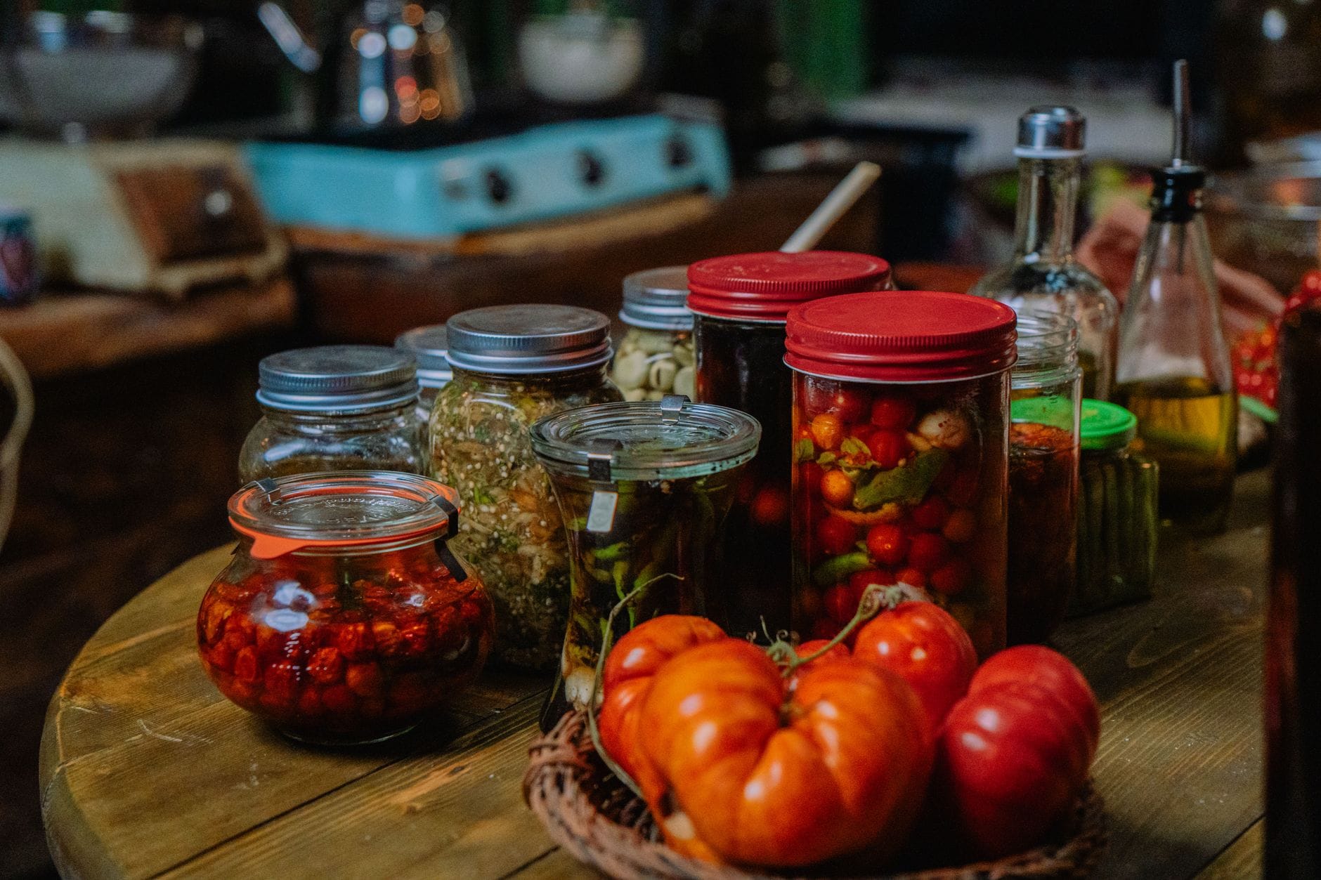 Jars of preserves beside fresh produce
