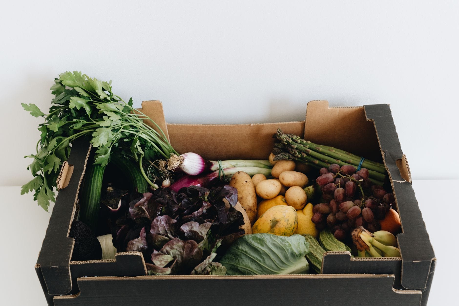 A cardboard box filled with fresh vegetables