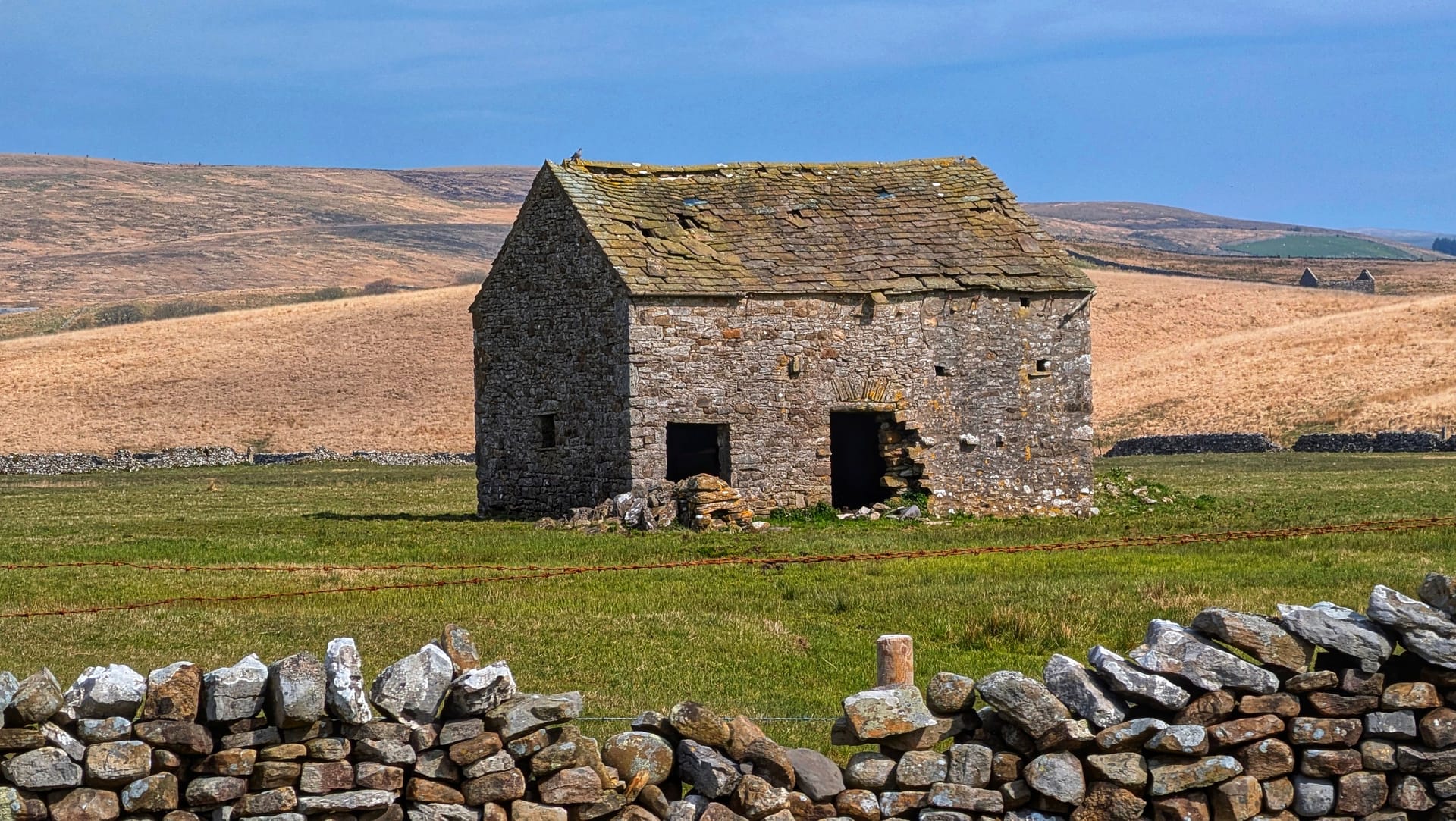 A stone barn among green fields in rural England
