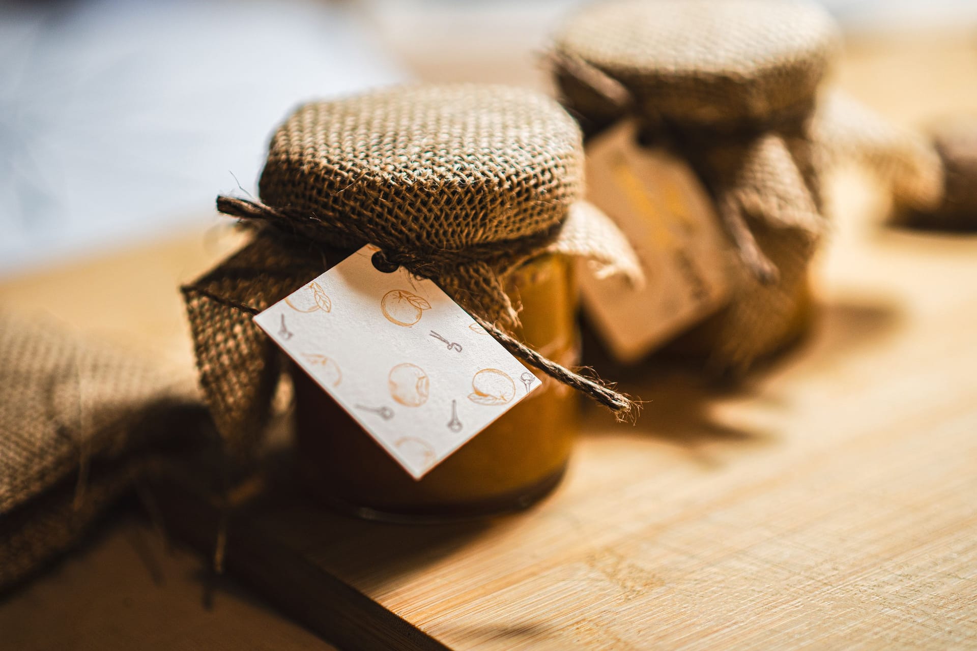 Homemade jam jars with labels on a wooden table