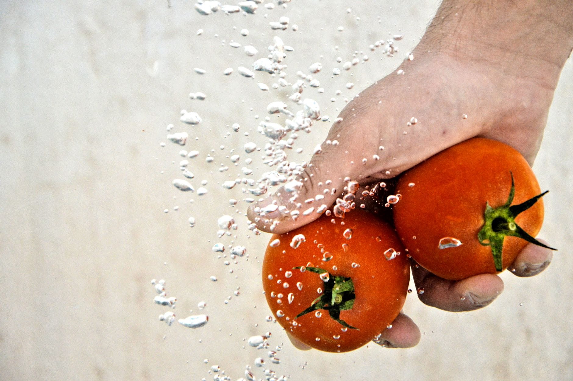 Washing fresh tomatoes under running water